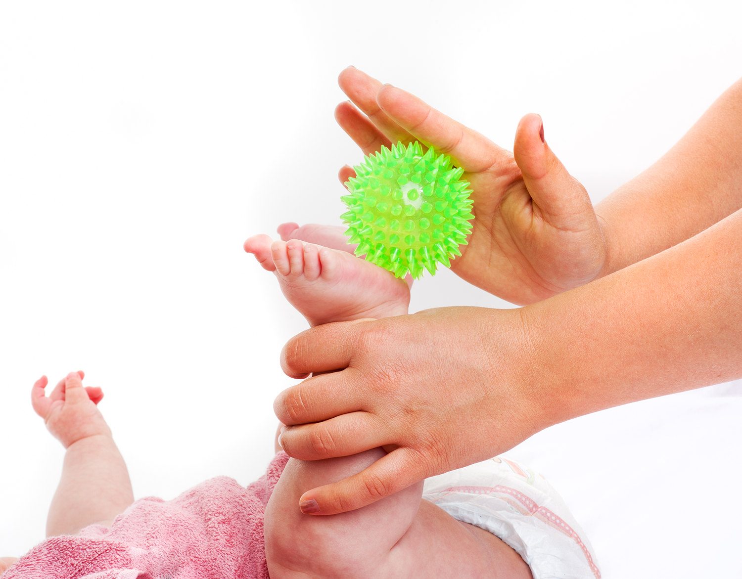Fußmassage eines Babyfußes mit einem Igelball